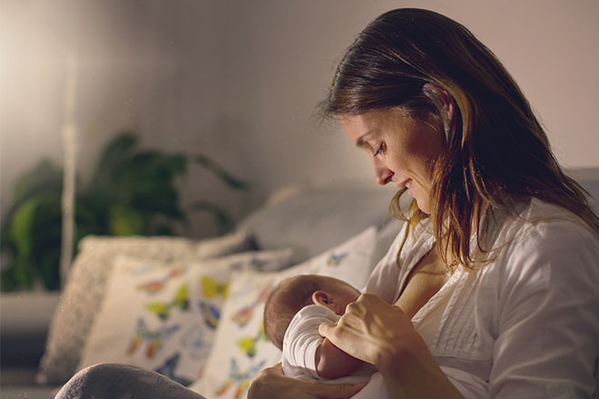 Una donna allatta il proprio piccolo