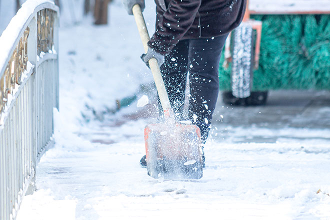 uomo pulisce l'atrio di casa dalla neve
