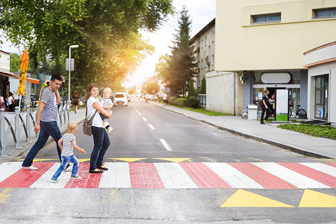 Famiglia attraversa la strada sulle strisce pedonali