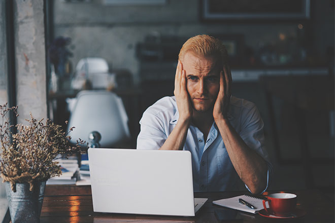 Uomo davanti al computer preoccupato per la sicurezza della sua Wifi