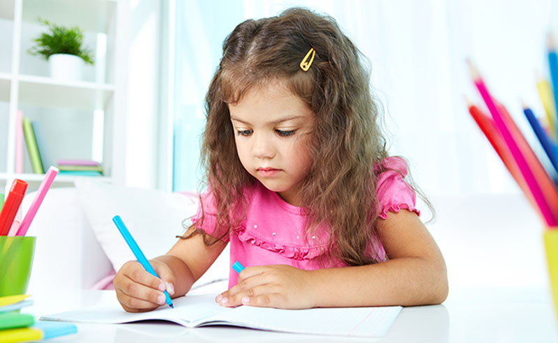 Bambina che fa i compiti delle vacanze a casa