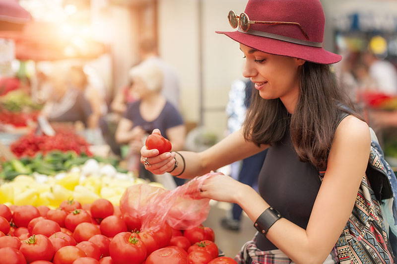 ragazza sceglie pomodori freschi al mercato