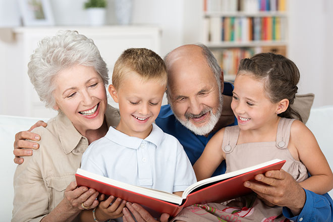 Nonni che leggono un libro ai nipoti