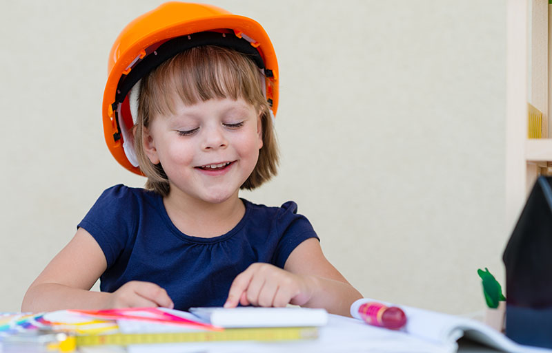 bambina gioca felice protetta dal caschetto